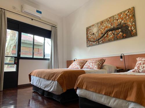 una camera d'albergo con due letti e una finestra di Costa Rica Soho Rooms a Buenos Aires