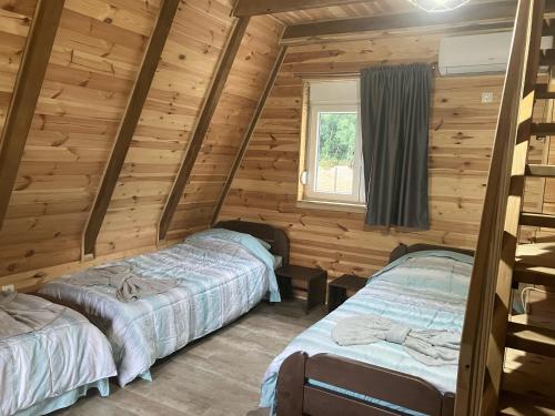 a bedroom with two beds in a log cabin at Mountain View Resort in Gusinje