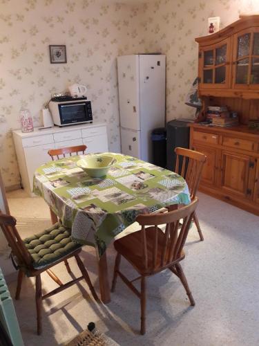 une cuisine avec une table avec des chaises et un réfrigérateur dans l'établissement Joli appt 2 chambres et studio avec parking dans résidence ombragée et calme 5mns plage et commerces, au Grau-du-Roi