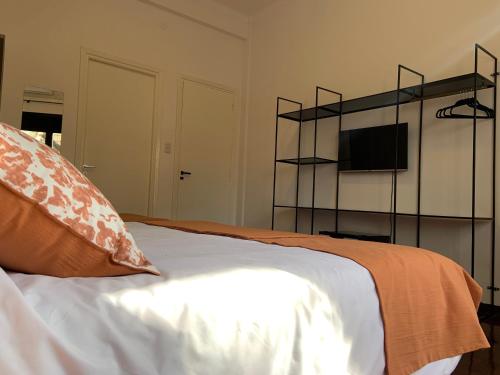een slaapkamer met een bed en een televisie op een plank bij Costa Rica Soho Rooms in Buenos Aires