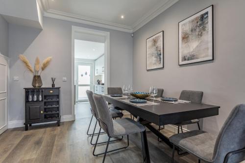 a dining room with a black table and chairs at Luxury Edwardian Townhouse in Belfast in Belfast
