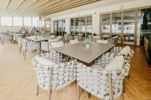 a dining room with tables and white chairs at Hotel Green Park Service Perfected in Garmen