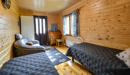 sypialnia z łóżkiem i krzesłem w drewnianym domku w obiekcie Villa Kastehelmi w mieście Suonenjoki