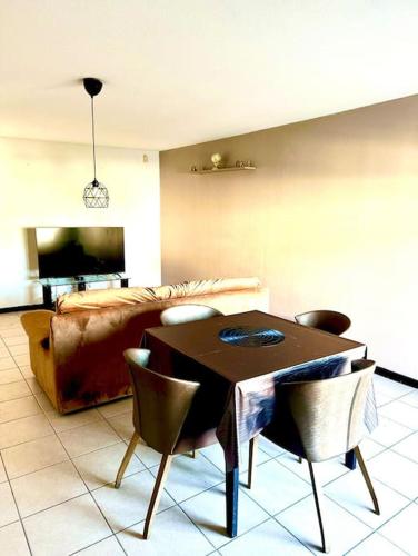 un salon avec une table, des chaises et un canapé dans l'établissement Appartement en résidence tout confort, à Marseille