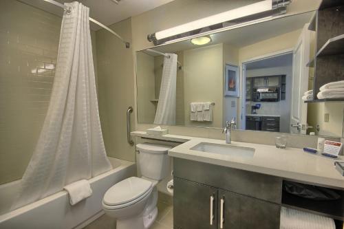a bathroom with a toilet and a sink and a tub at Candlewood Suites Columbus - Grove City by IHG in Grove City