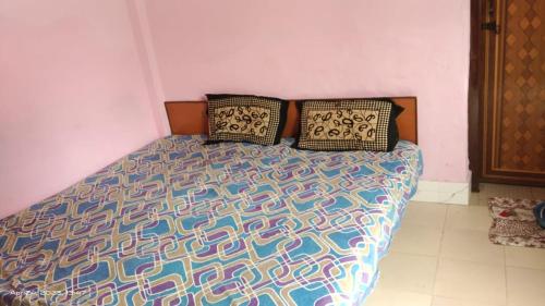 uma cama com duas almofadas num quarto em Shivangari Home Stay By WB Homes em Mandāli