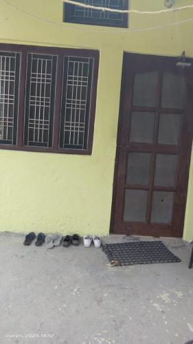 um grupo de sapatos sentados em frente a um edifício em Shivangari Home Stay By WB Homes em Mandāli