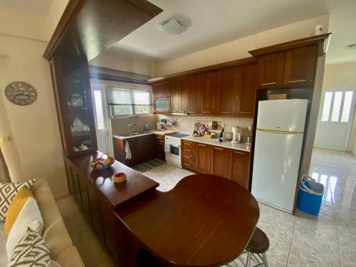 a kitchen with a wooden table and a refrigerator at Siamos Villa in Vonitsa