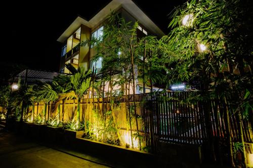 a building with a fence and trees in front of it at Lancelynk Retreat Hoi An in Hoi An