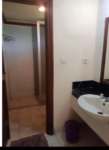 a bathroom with a white sink and a shower at Apartment Marbella Anyer in Serang