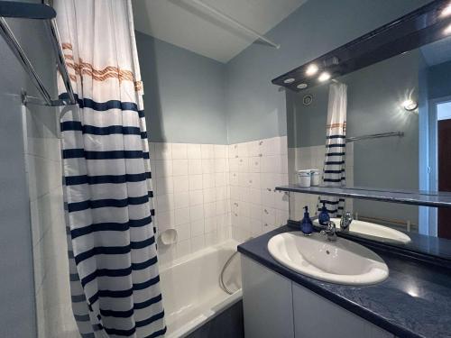 une salle de bain avec un lavabo et un rideau de douche dans l'établissement Appartement rénové 3 pièces, vue mer, accès direct plage, parking privé, 4 couchages - FR-1-224C-89, à Saint-Jean-de-Monts