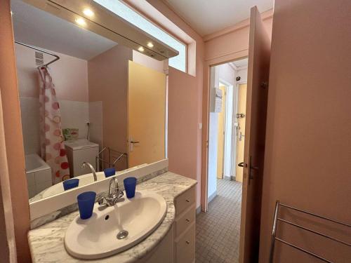 une salle de bain avec un lavabo et un grand miroir dans l'établissement Appartement 3 pièces, 6 couchages, balcon, parking, proche mer - FR-1-224C-263, à Saint-Jean-de-Monts
