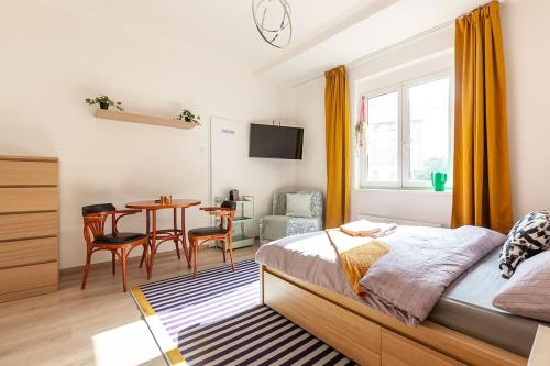 um quarto com uma cama e uma mesa com uma cadeira em Renovated Cosy & Quiet flat near Smichov Station em Praga
