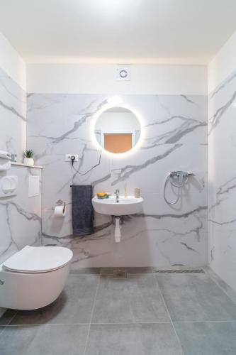 a white bathroom with a sink and a toilet at Beautiful apartment Lena in Split