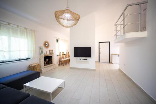 a living room with a couch and a tv at "Blue Bay Villa" at Gjiri Lalzit, Lalzi Bay, Lura 1 in Durrës