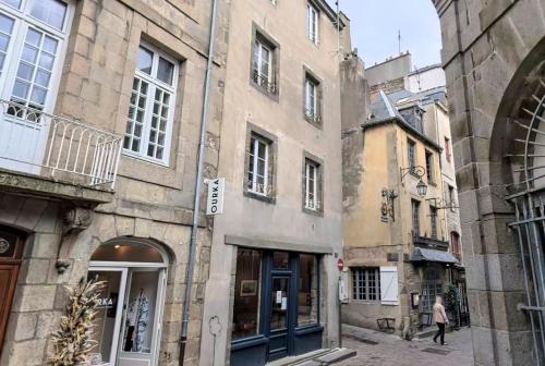 Une ruelle dans une vieille ville avec des bâtiments dans l'établissement COLLINS Studio Saint Malo intra muros 2 pers WIFI, à Saint-Malo
