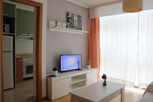 een woonkamer met een televisie op een witte kast bij Las Rosas in Vigo