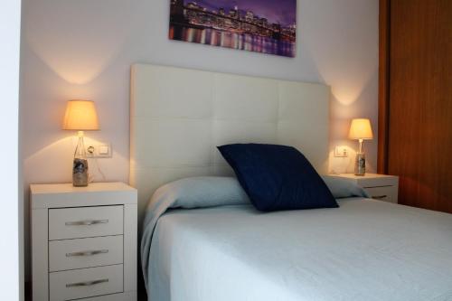 a bedroom with a bed with two night stands and two lamps at Las Rosas in Vigo