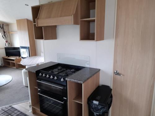 a kitchen with a stove top oven in a room at 48 Oak Village Grange Leisure Park in Mablethorpe