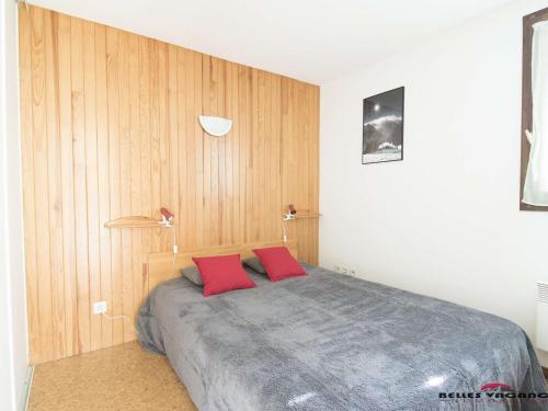 une chambre avec un lit avec deux oreillers rouges dans l'établissement Appartement T3 6 pers. à St-Lary Soulan - Proche télécabine et thermes, avec jardin et parking privé - FR-1-296-125, à Vielle-Aure