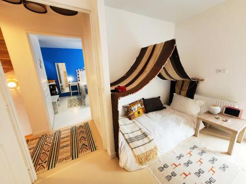 Dormitorio pequeño con cama y mesa en Dream of Mediterranean house, Jacuzzi, BBQ, Délices ensoleillés en Sartrouville