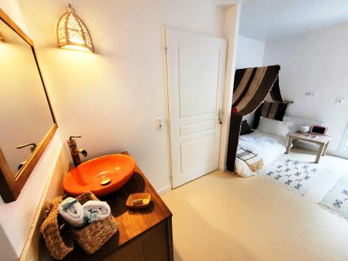 a bathroom with a sink and a bedroom with a bed at Dream of Mediterranean house, Jacuzzi, BBQ, Délices ensoleillés in Sartrouville
