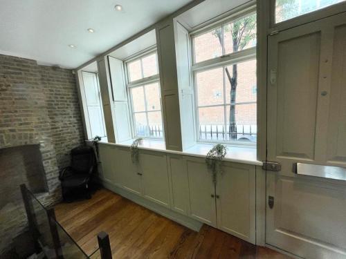 Il comprend un salon doté de fenêtres et d'une cheminée. dans l'établissement 4 floor Apartment in Covent Garden, à Londres