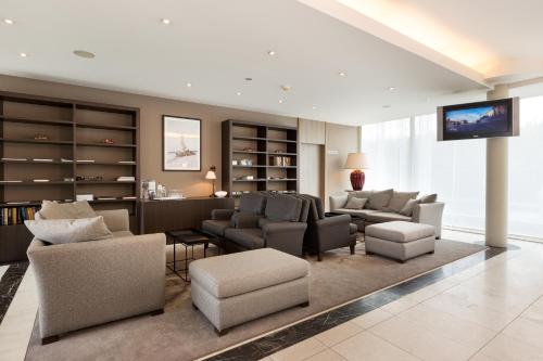 ein Wohnzimmer mit Sofas und Stühlen sowie einem TV in der Unterkunft Hotel Restaurant Weinebrugge in Brügge