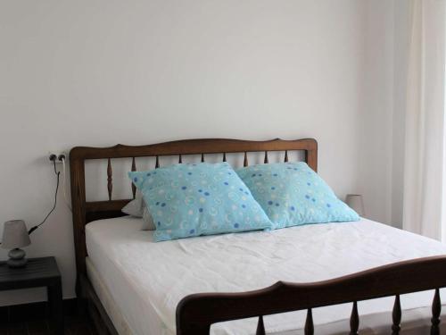 een bed met twee blauwe kussens erop bij Appartement Port-la-Nouvelle, 2 pièces, 4 personnes - FR-1-229C-55 in Port-la-Nouvelle