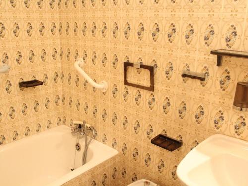 een badkamer met een wit bad en een wastafel bij Appartement Port-la-Nouvelle, 2 pièces, 4 personnes - FR-1-229C-55 in Port-la-Nouvelle