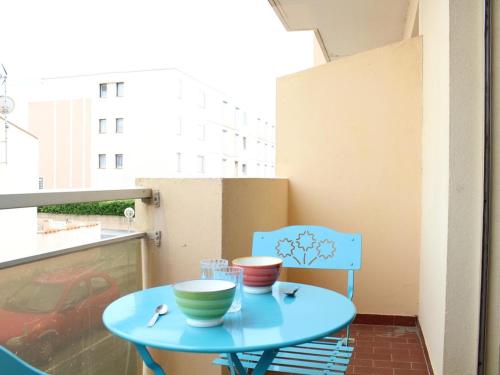 une table bleue et une chaise sur un balcon dans l'établissement Appartement traversant avec balcons, parking privé, à 250m de la plage - Port-la-Nouvelle - FR-1-229C-55, à Port-la-Nouvelle