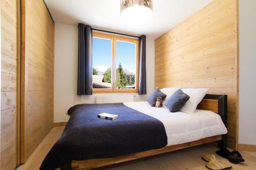 a bedroom with a large bed with a window at Résidence Neige Et Soleil - 5 Pièces pour 10 Personnes 144 in Les Deux Alpes