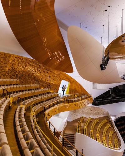a large auditorium with a man standing on a stage at Studio de charme in Pantin