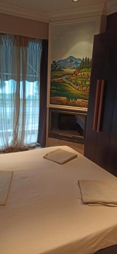 a bedroom with a bed with a painting on the wall at Agathoupoli beach 
