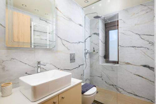a white bathroom with a sink and a shower at Giannis Place I in Áyios Vasílios