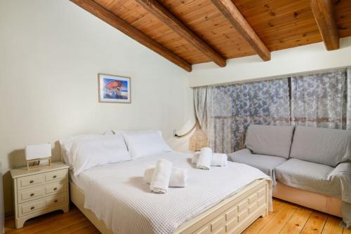 a bedroom with a bed and a couch at Giannis Place I in Áyios Vasílios