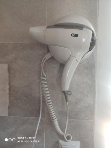 a hair dryer is attached to a wall at Guesthouse Mery in K'obulet'i
