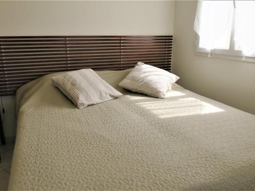 - un lit avec 2 oreillers dans une chambre dans l'établissement Appartement Trégastel, 2 pièces, 4 personnes - FR-1-368-17, à Trégastel