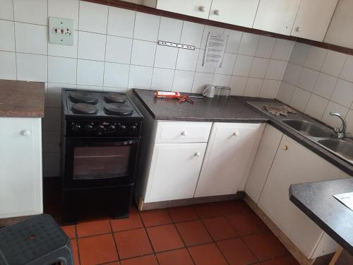Il comprend une petite cuisine équipée d'une cuisinière et d'un évier. dans l'établissement 3 Bedroom Manor Gardens House, à Durban