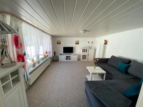 sala de estar con sofá y TV en Ferienhaus mit Wasserblick auf der Insel Usedom, en Krummin