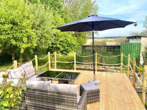 un patio con sofá y sombrilla en Ferienhaus mit Wasserblick auf der Insel Usedom, en Krummin