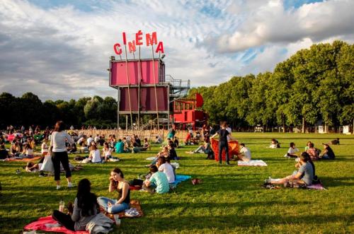 a crowd of people sitting on the grass in a park at Studio de charme in Pantin