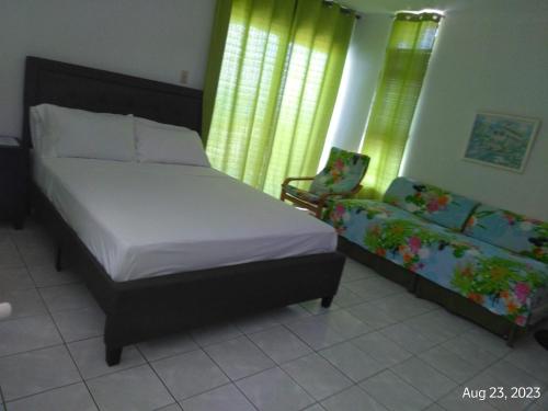 een slaapkamer met een bed en een bank bij Irresistible View-Mobay Club 1408 in Montego Bay