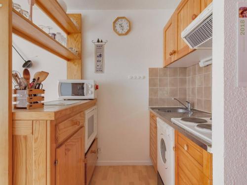 une cuisine avec un évier et un micro-ondes dans l'établissement Studio Cabine pour 6 pers avec Balcon, Parking et Wifi - Esquièze-Sère - FR-1-402-30, à Esquièze - Sère