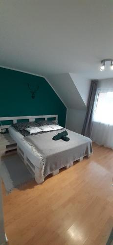 a bedroom with a bed with a green wall at Wypoczynek Pod Jelonkiem in Krościenko