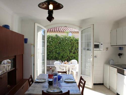 une cuisine avec une table et une salle à manger avec une table et des chaises dans l'établissement Maison familiale 3 pièces, terrasse, proche plage, parking - Port-la-Nouvelle - FR-1-229C-688, à Port-la-Nouvelle