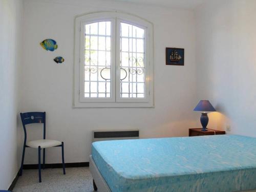 une chambre avec un lit, une fenêtre et une chaise dans l'établissement Maison familiale 3 pièces, terrasse, proche plage, parking - Port-la-Nouvelle - FR-1-229C-688, à Port-la-Nouvelle