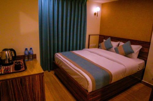 ِAfnan hotel في العقبة: غرفة نوم بسرير كبير مع ستائر زرقاء