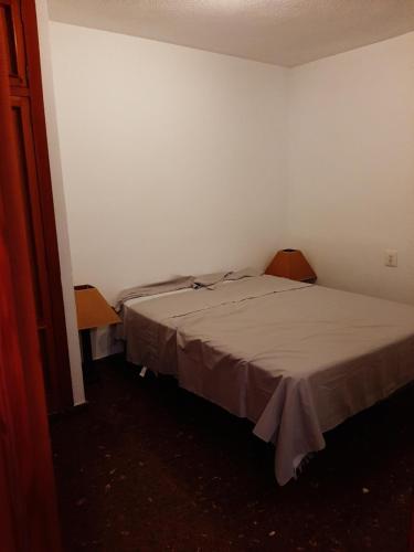 ein kleines Schlafzimmer mit einem Bett und zwei Stühlen in der Unterkunft Piso en Paseo Germanias in Gandía