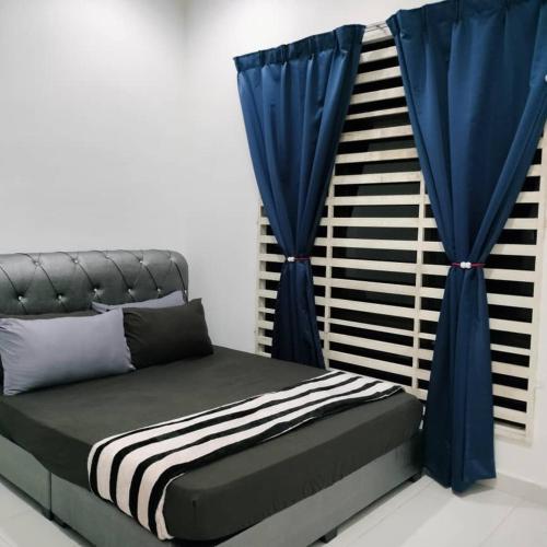 Cette chambre comprend un lit avec des rideaux bleus. dans l'établissement KUALA TERENGGANU GUESTHOUSE-FREE WIFI-NEAR NASI DAGANG ATAS ToL-UNIT A-1 BILIK AIRCOND 2 BILIK KIPAS, à Kuala Terengganu